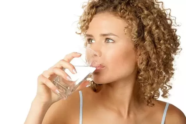 Gadis itu mengikut diet untuk malas, minum segelas air sebelum makan
