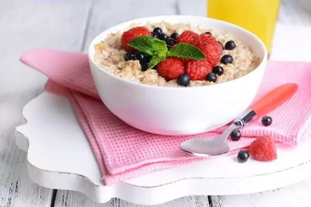 Menu diet untuk malas termasuk oatmeal dengan beri untuk sarapan pagi